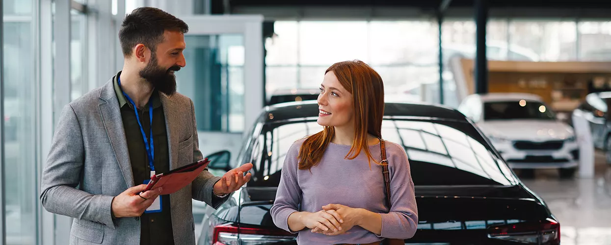 Car salesman talking to a customer about a new vehicle