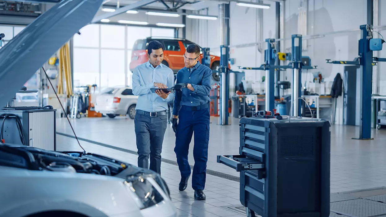 Service mechanic showing a car owner a clipboard