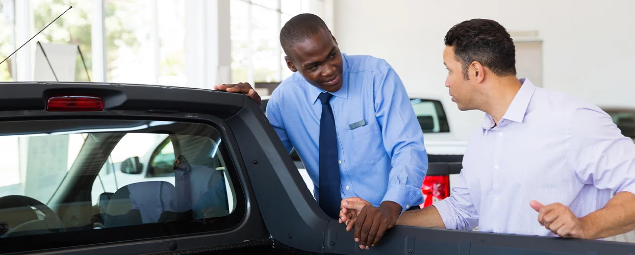 two people discussing truck in showroom