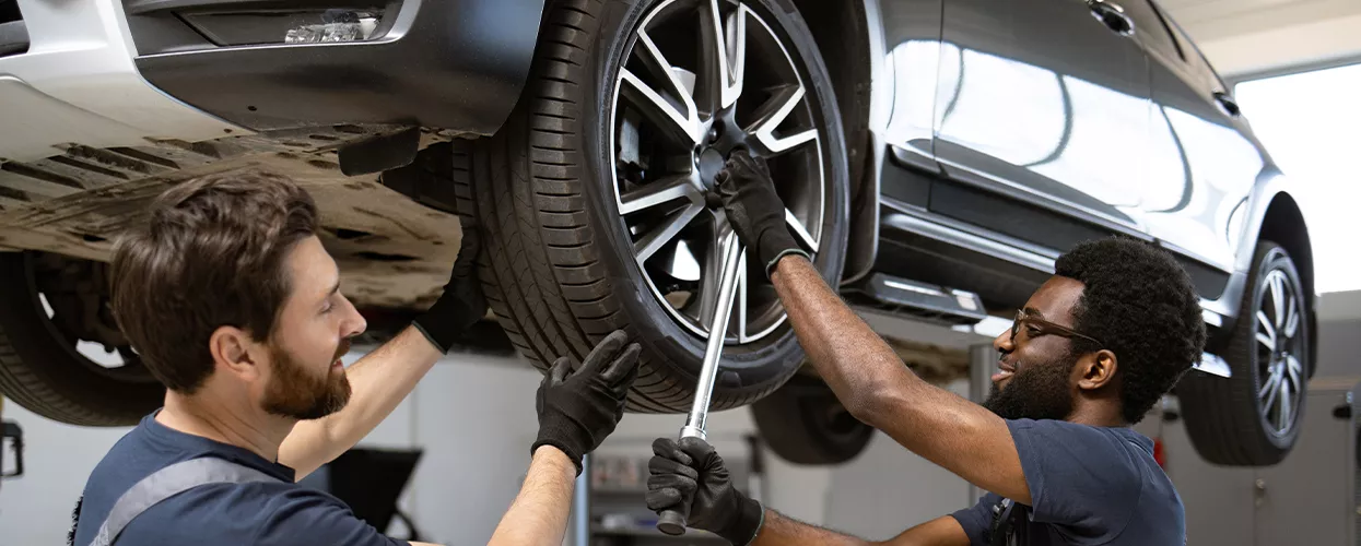 Two service mechanics servicing a car