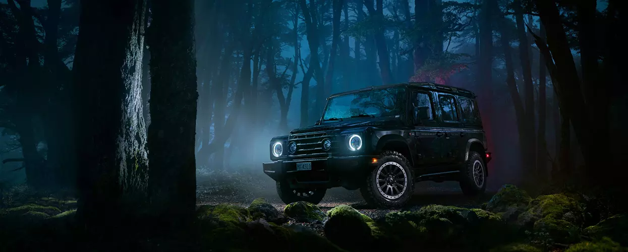 INEOS vehicle driving in a forest at night