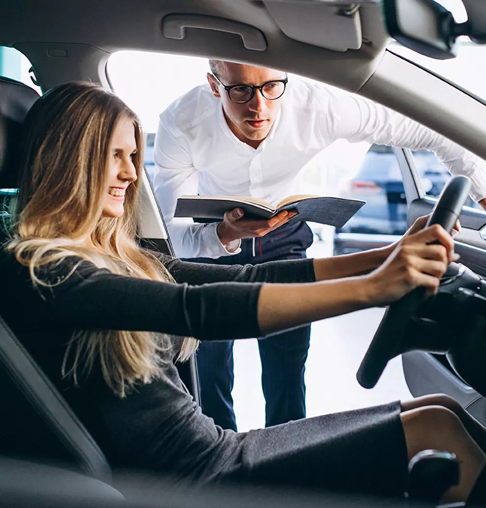 Woman sitting in a new vehicle in a car dealership