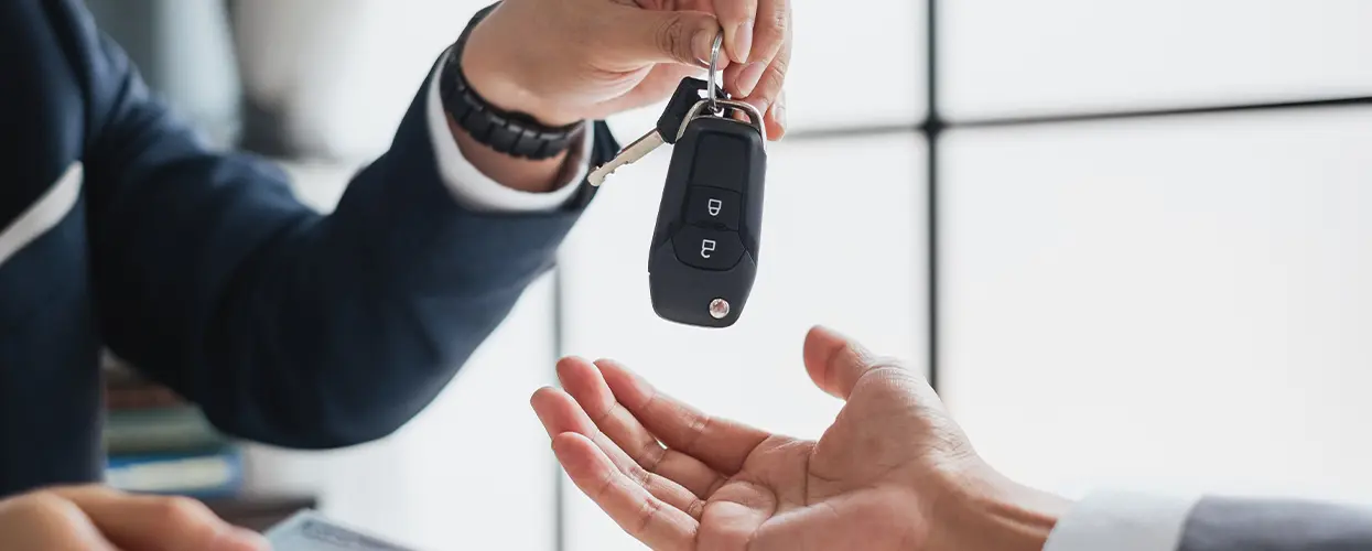 Car salesman handing keys over