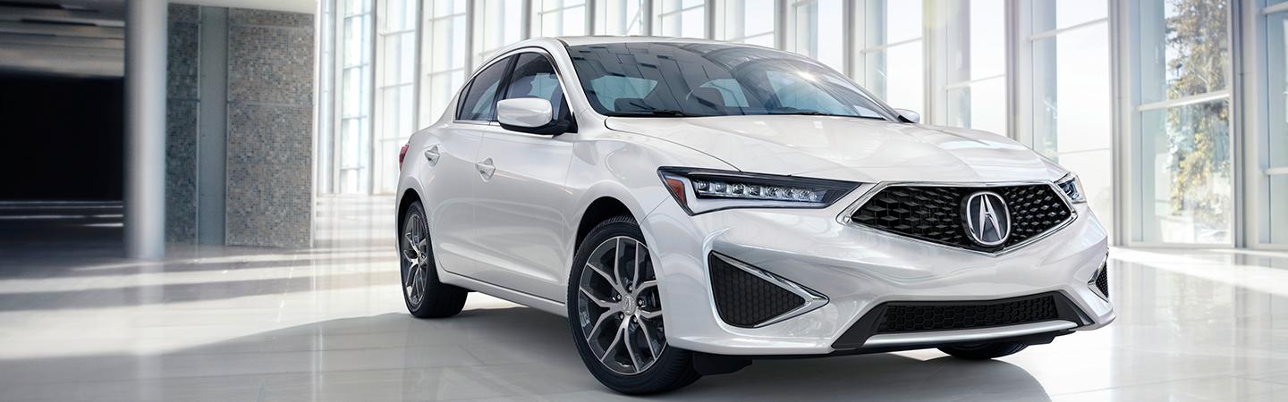 white Acura parked in showroom