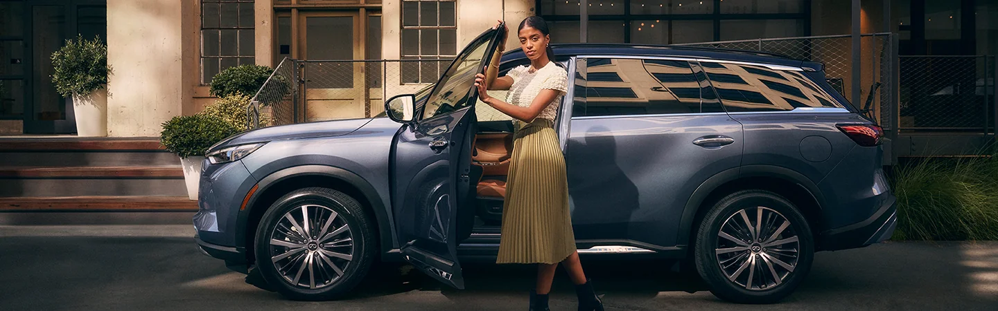 Blue 2025 INFINITI QX60 women opening door