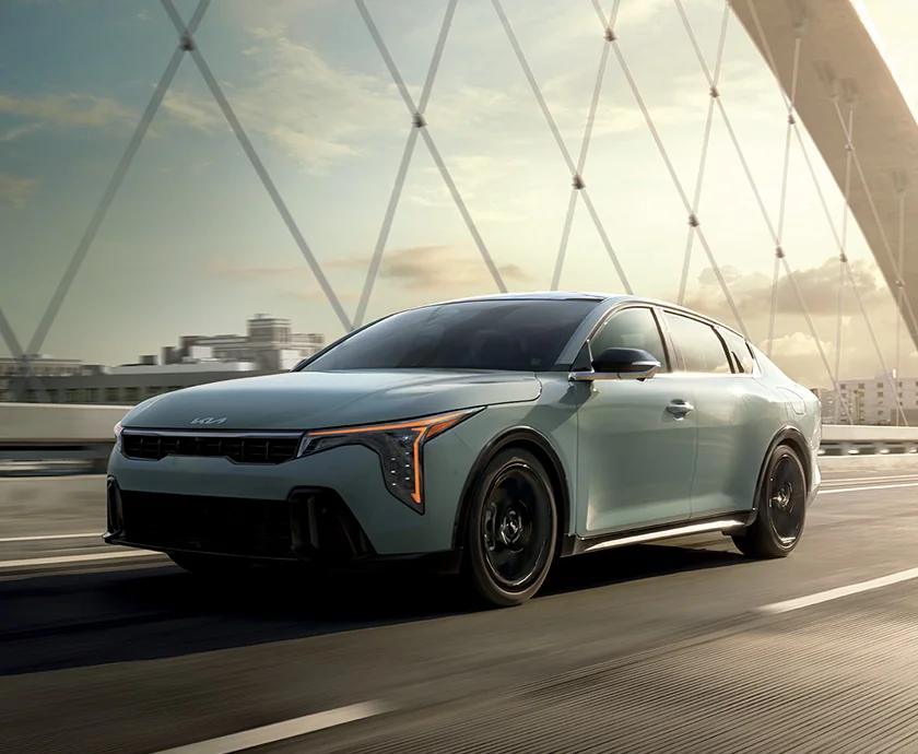 a light blue 2026 Kia K4 exterior view crossing a bridge