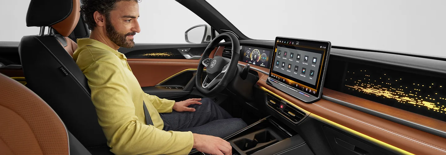 Interior view of a person checking out the dashboard and tech of a 2025 Volkswagen Tiguan