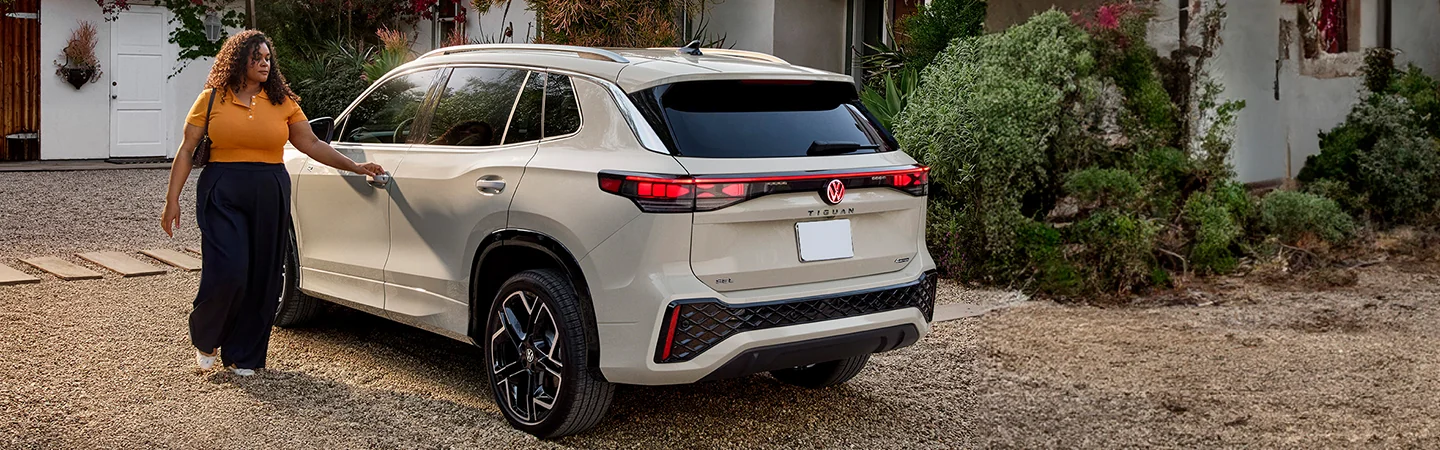 A back view of a parked 2025 Volkswagen Tiguan in a driveway