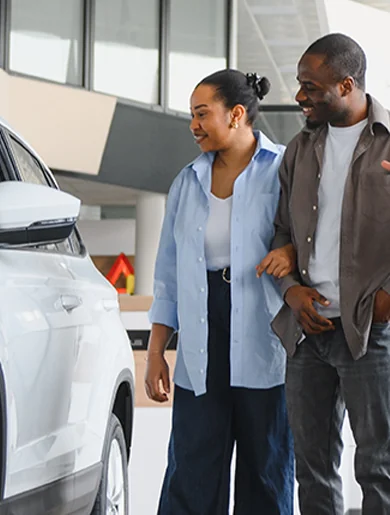 couple in car showroom checking out vehicles
