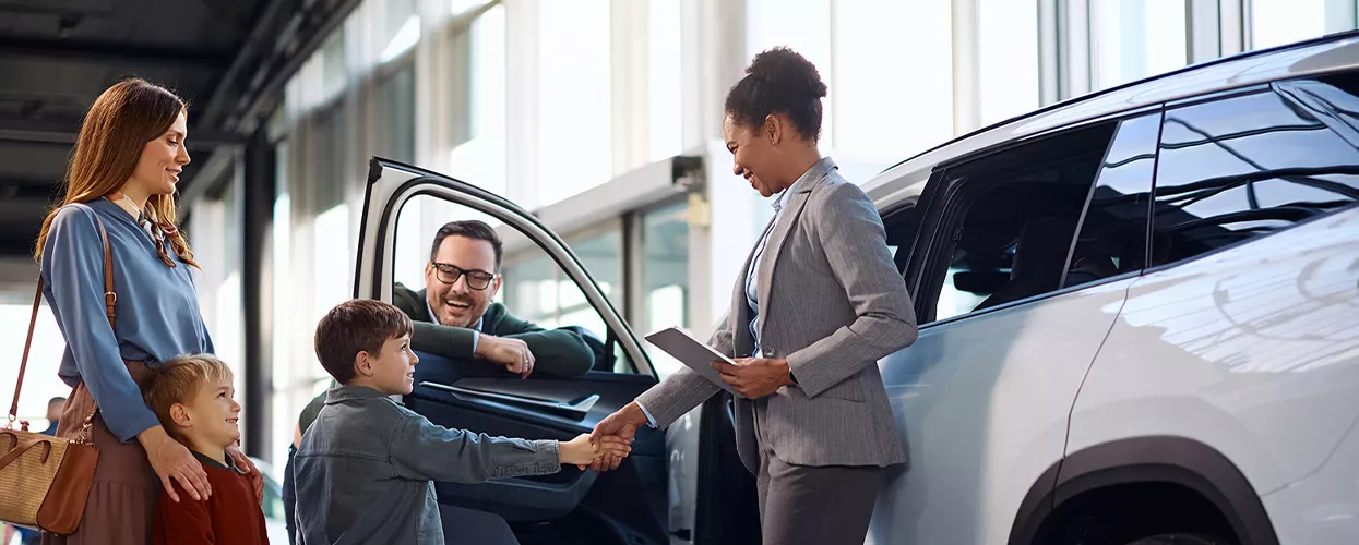 Family looking at a new vehicle in a car dealership