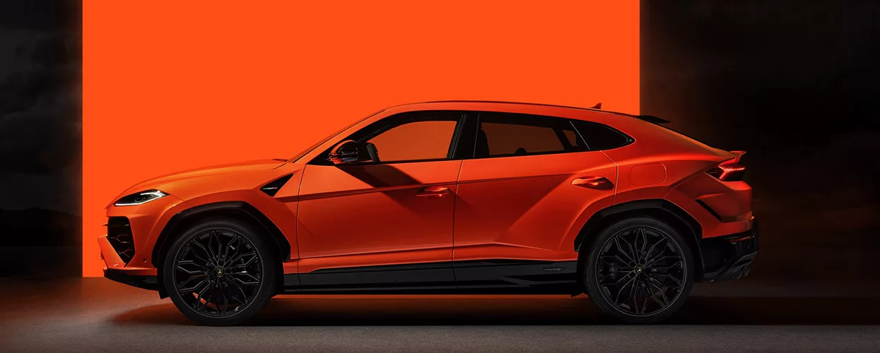 and orange Lamborghini Urus displayed at a dealership