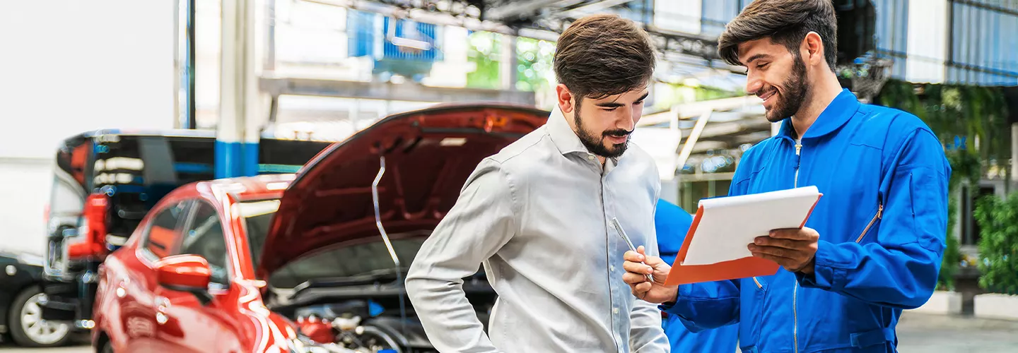 Service mechanic working with a customer and showing them a clipboard