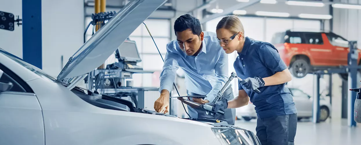 Hyundai technician performing service on a Hyundai Tucson in a service bay