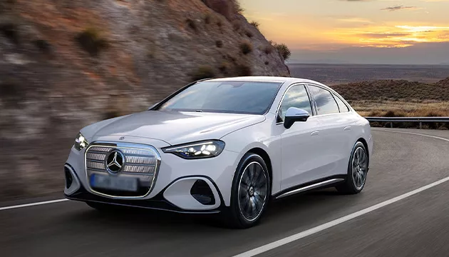 Image of a white Mercedes-Benz driving an a curvy road