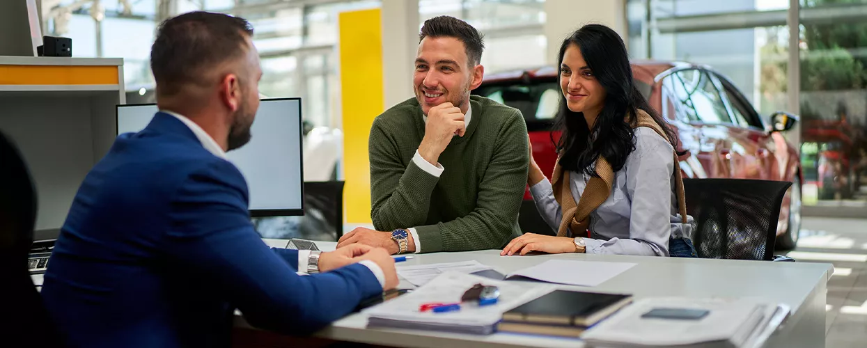 Car salesman talking to a customer about a new vehicle