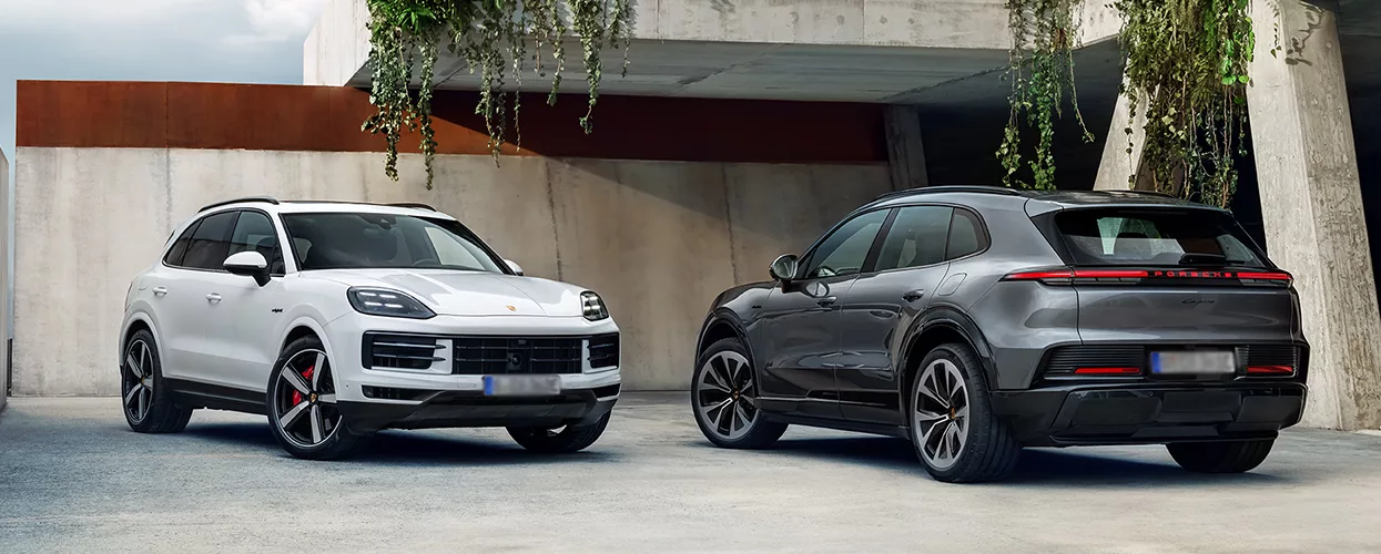 A gray and a white Porsche Cayenne parked in a driveway