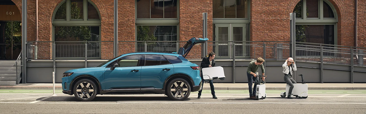 light blue 2025 Honda Prologue EX being unloaded with electric scooters