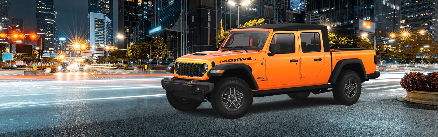 Side view of an orange 2025 Jeep Gladiator on a city street