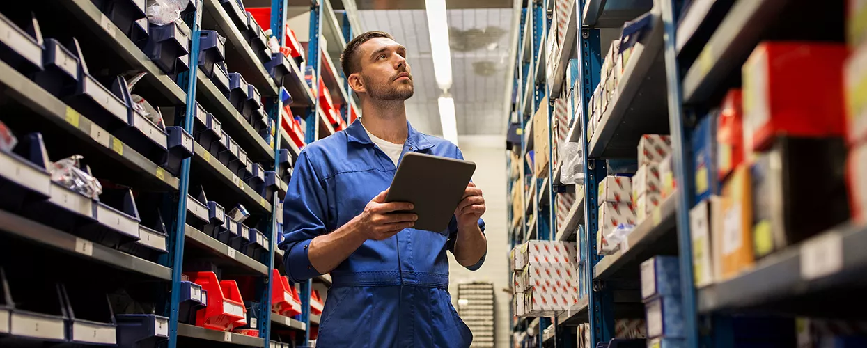 Service mechanic looking at parts in a warehouse