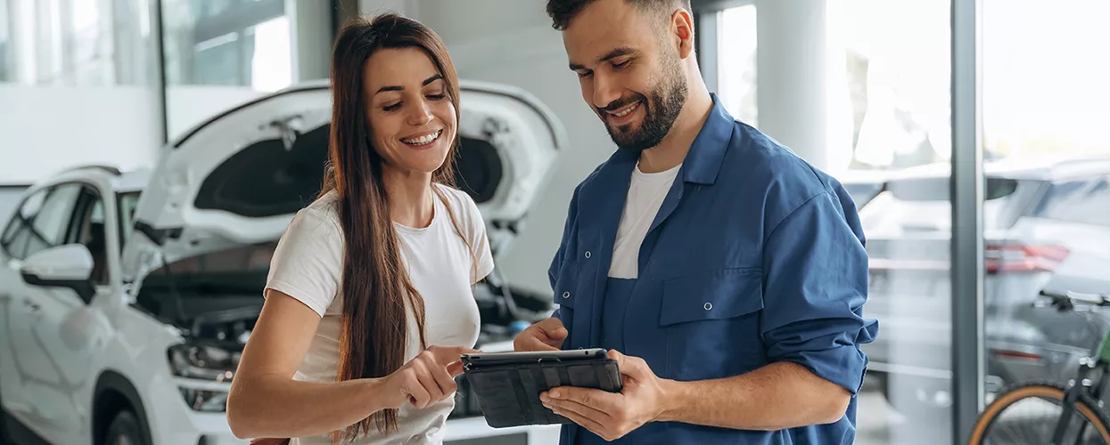 Service mechanic showing a customer an ipad in a service bay