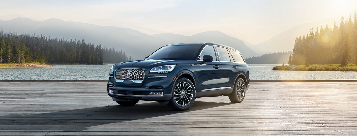 Dark blue Lincoln Aviator parked near a lake in the mountains