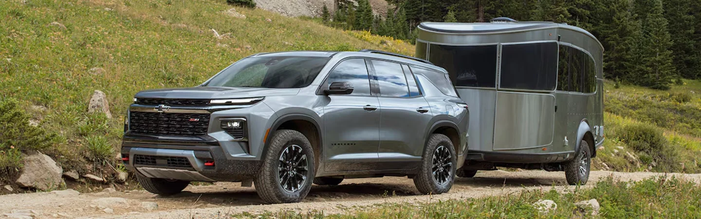 Side view of a gray 2024 Chevrolet Traverse pulling a trailer