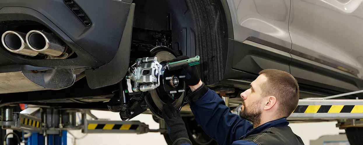 Service mechanic working on a vehicle's brakes
