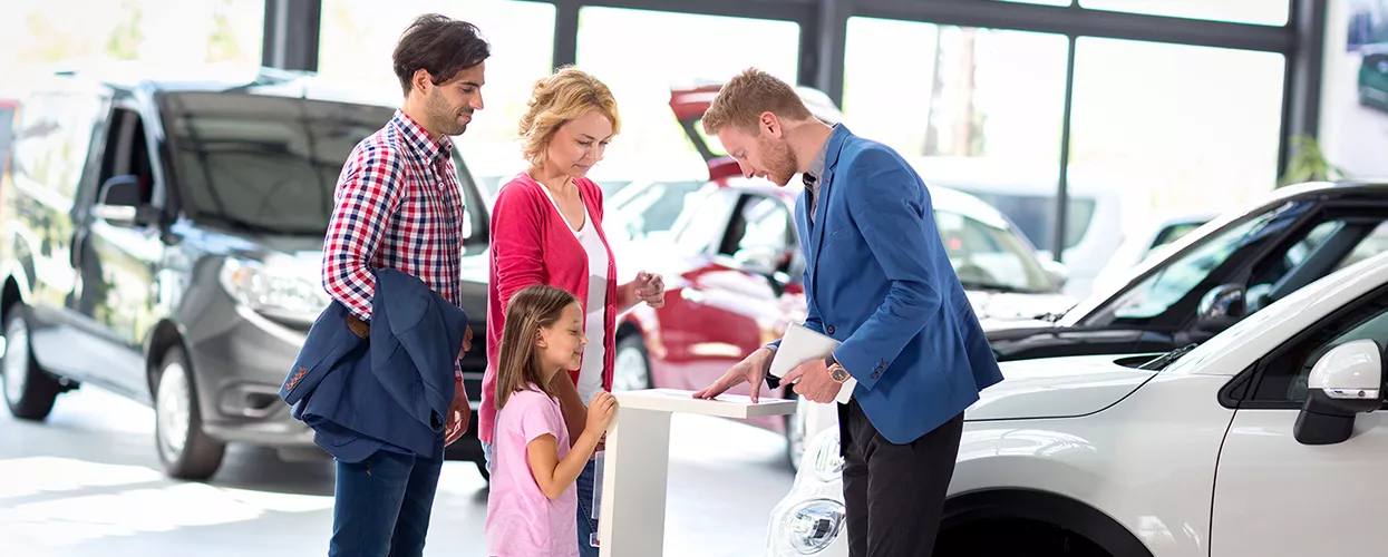 Car salesman talking to a family about a new vehicle