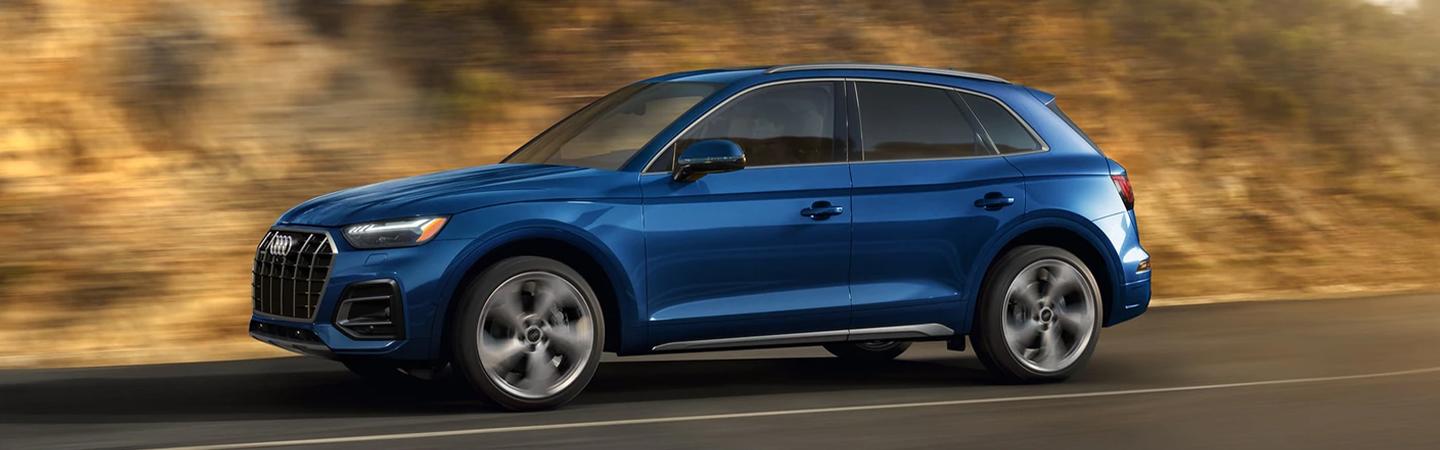 Side view of the passing by 2021 Blue Audi Q5