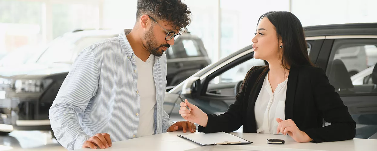 Car salesman walking a customer through a contract