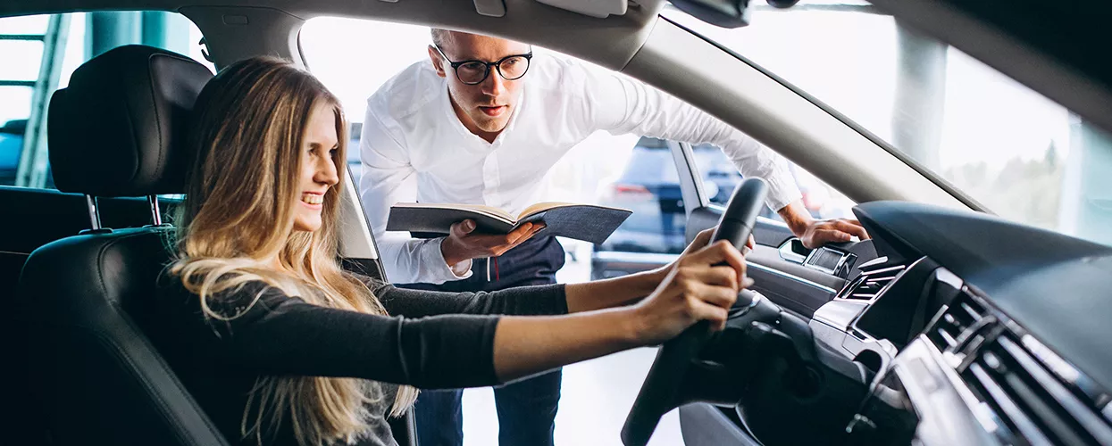 Car salesman showing a customer a vehicle in a dealership