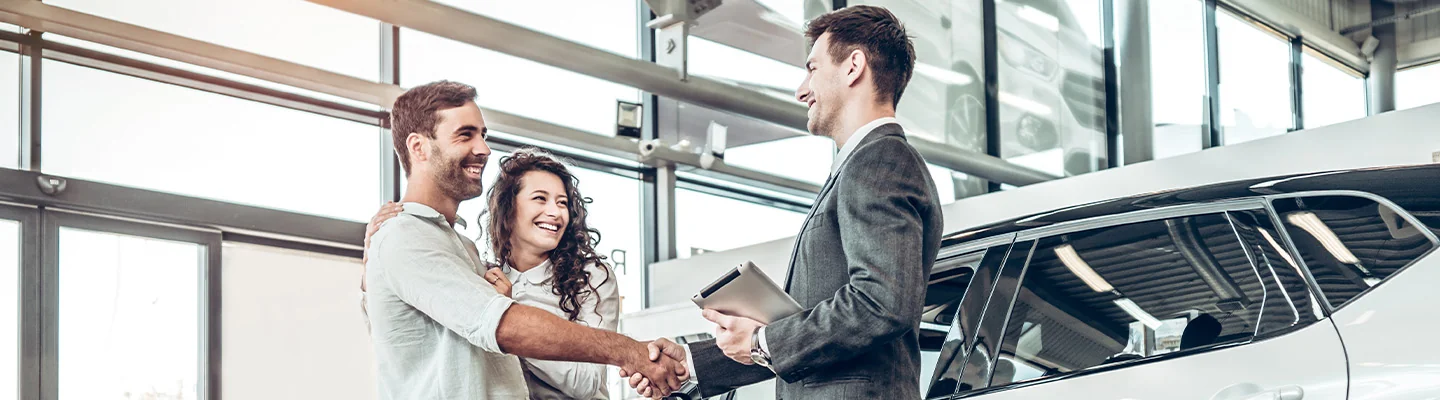 Sales person helping customers buy a new car