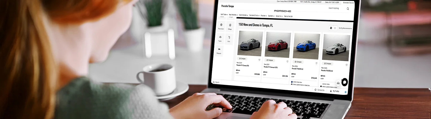 woman sitting at her table with a laptop open searching through Porsche Tampa inventory