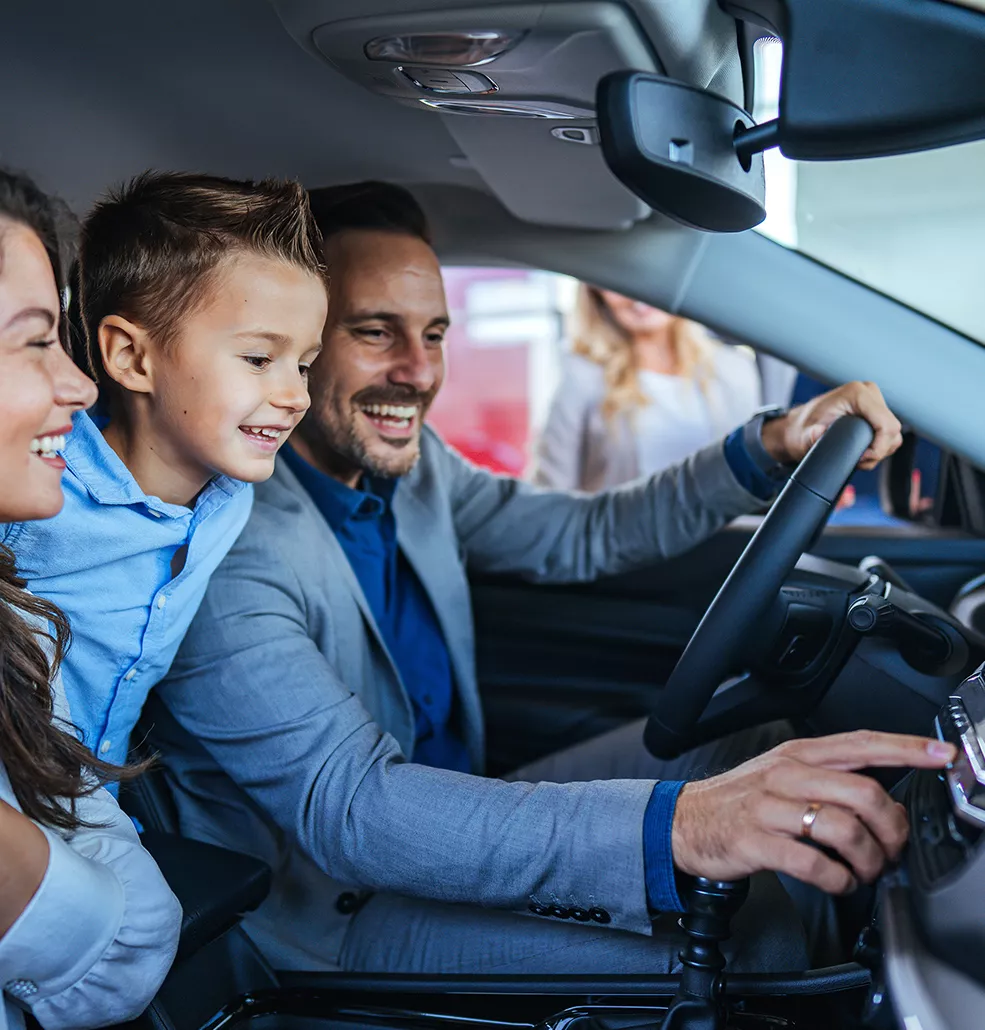 Family sitting in a new vehiicle at a car dealership