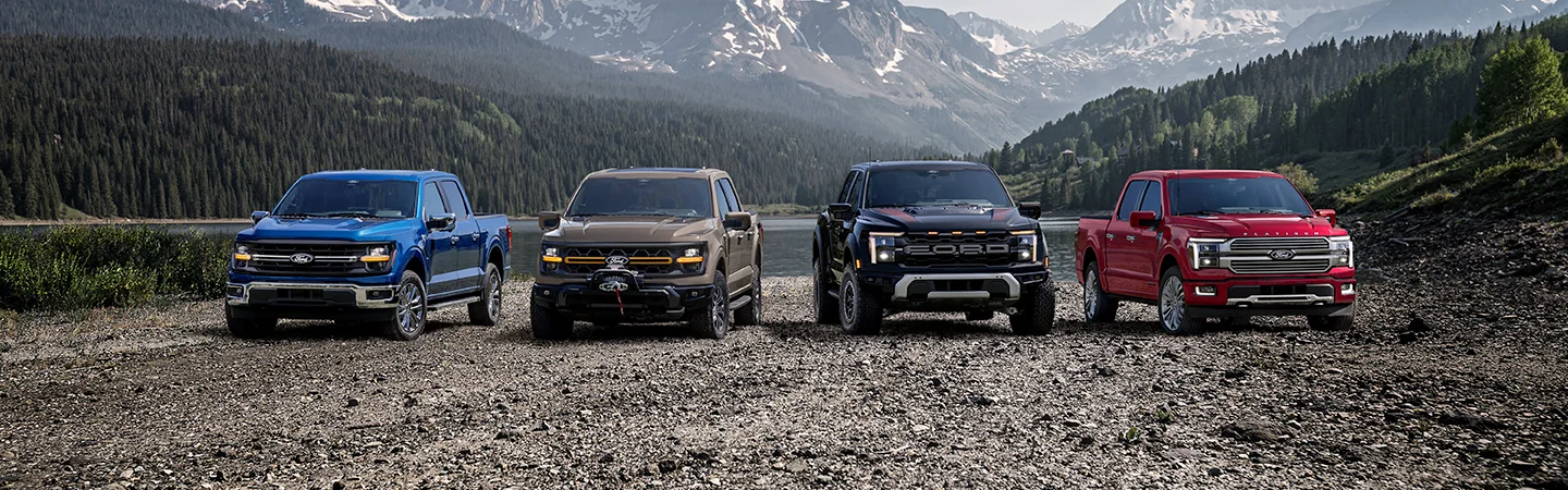 Model line up 2025 Ford trucks by a lake side