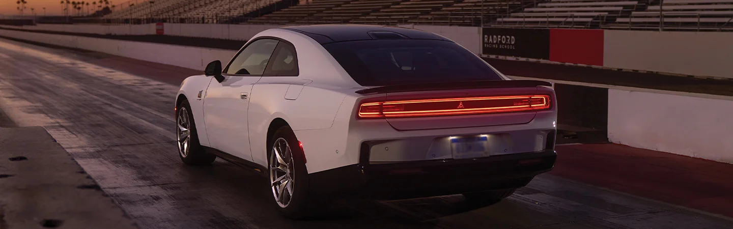 Back view of a white 2025 Dodge Charger parked on a race tack