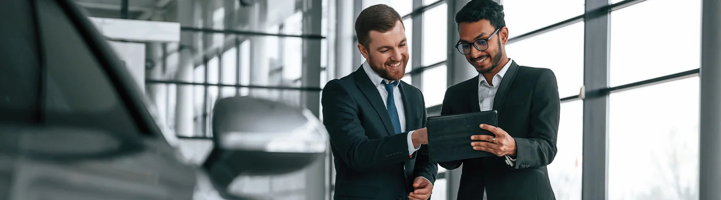 two people discussing specifications of a car purchase in the dealership