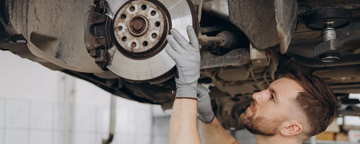 Service mechanic servicing a vehicle's brakes