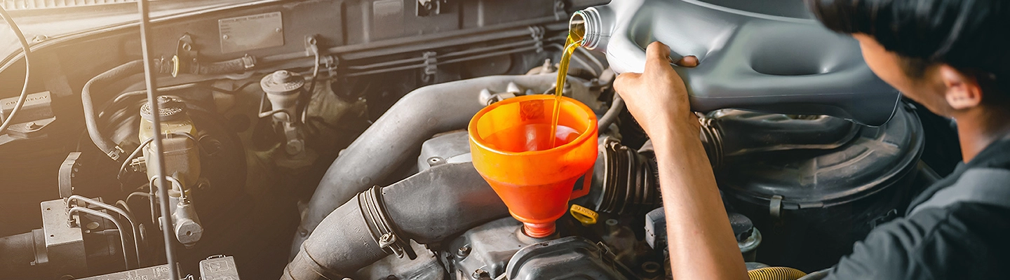 Person putting oil into an engine