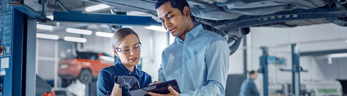 mechanic and tech looking over diagnostic on tablet