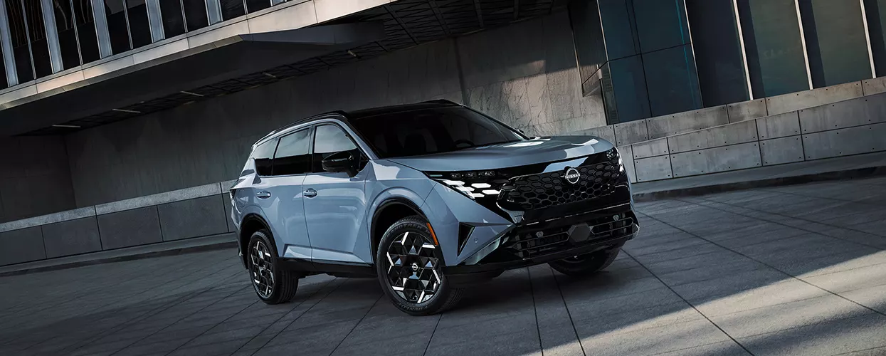 A gray 2027 Nissan SUV parked by a building in the city