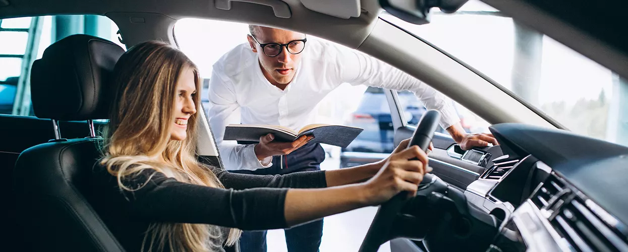 Sales person showing a women the inside of a new Nissan