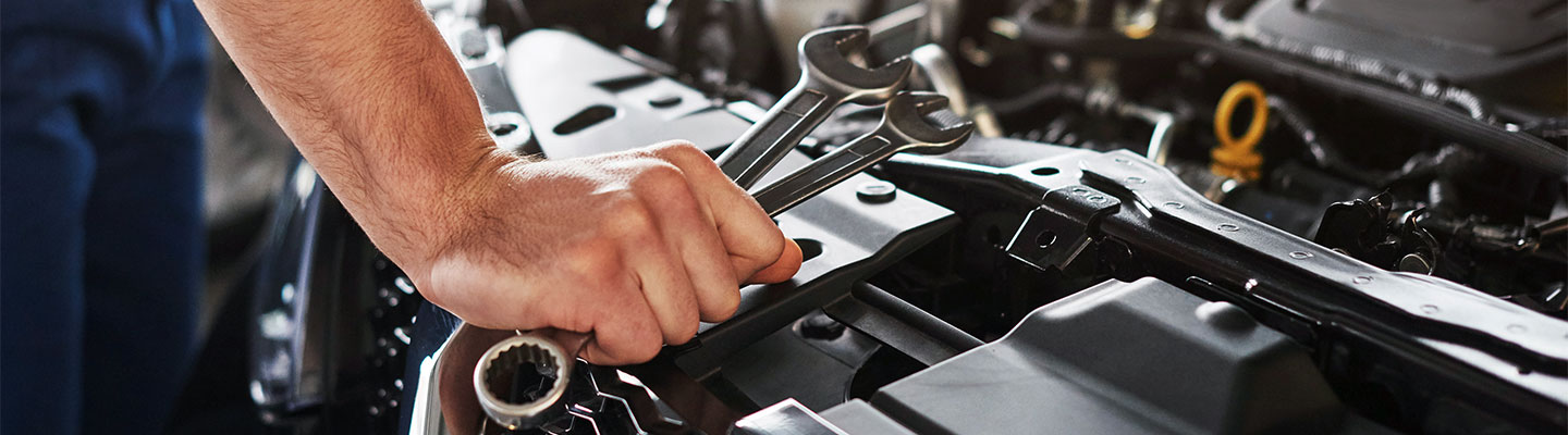 Close up view of a mechanic working on a car engine