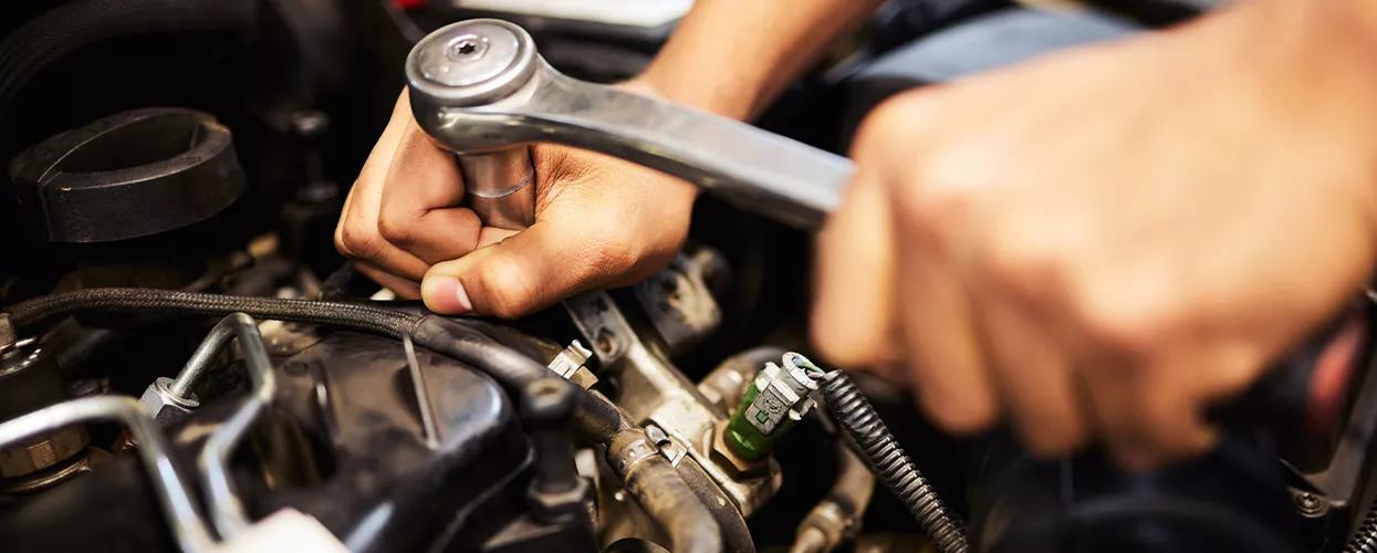 Service mechanic working on a car's engine