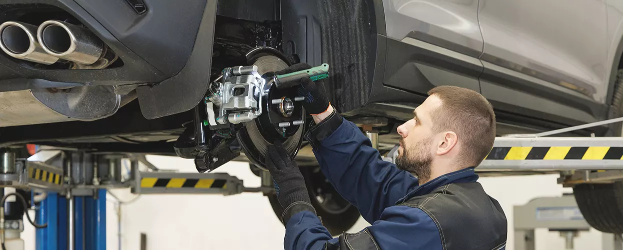 Service mechanic servicing a vehicle's brakes