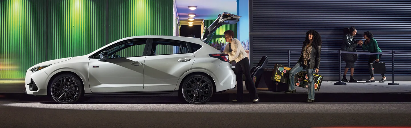 driver side view of a 2025 Subaru Impreza Base being loaded by two people