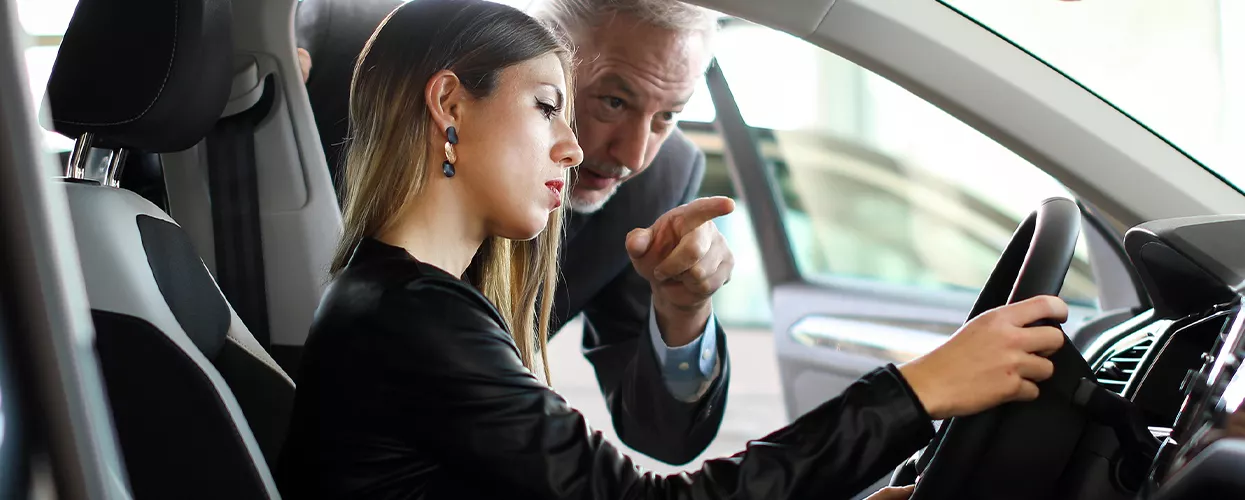 Sales person showing a women the inside of a new Nissan