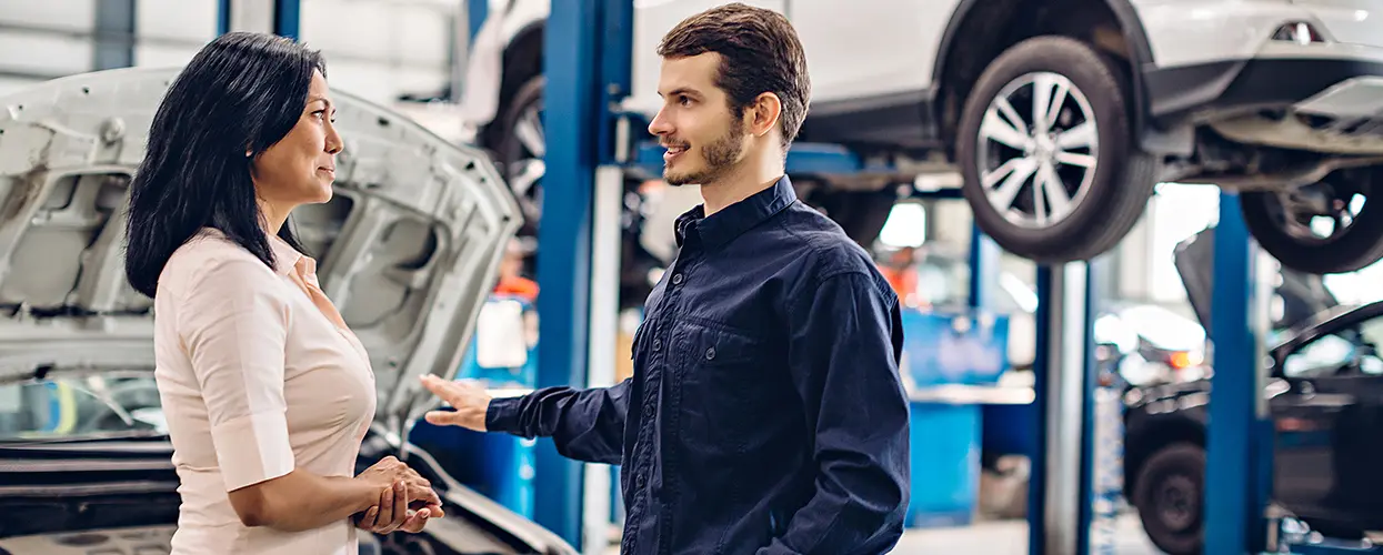woman showing car trunk to man