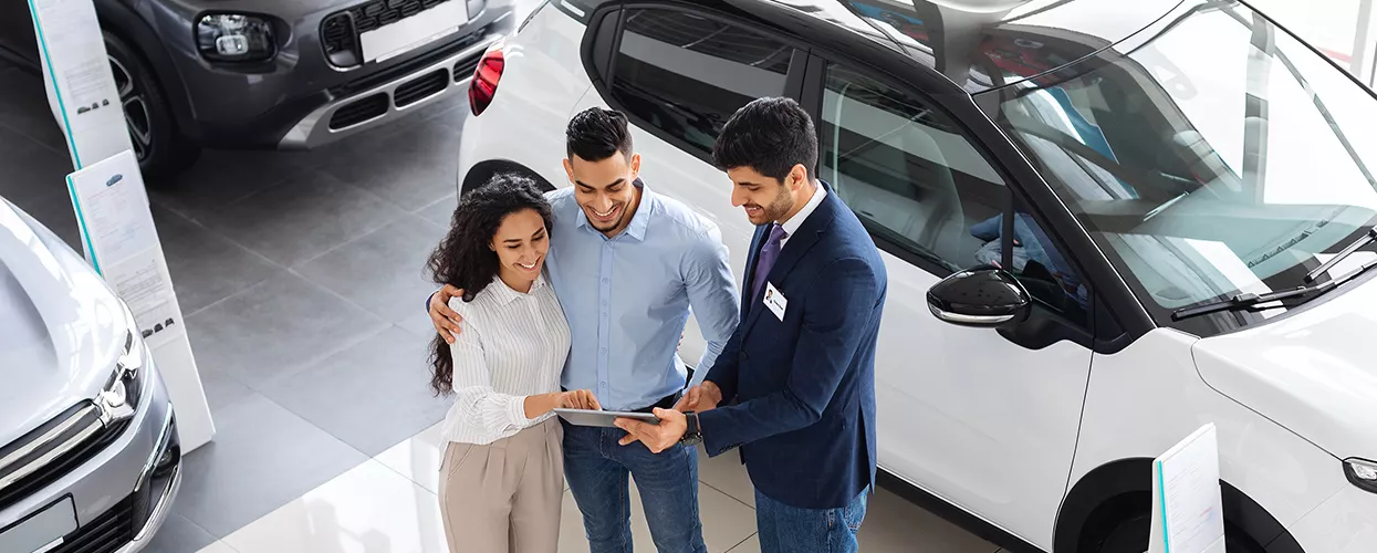 Car salesman showing a couple a vehicle