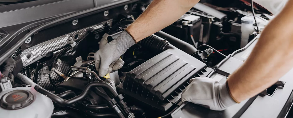 Service mechanic working on a car's engine
